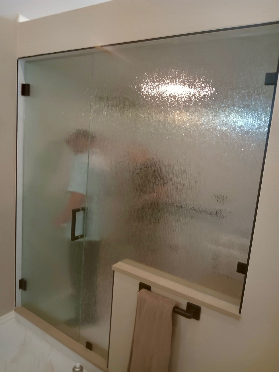Finished custom steam shower enclosure with rain pattern glass and protective Diamon-Fusion coating
