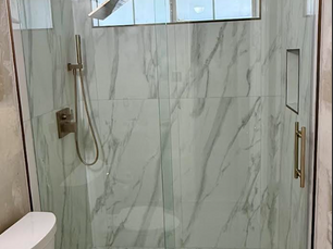 Single slider glass shower door in Murphy, Texas featuring Sleek Serenity hardware in brushed bronze, a ladder pull handle, and Diamon-Fusion coating.