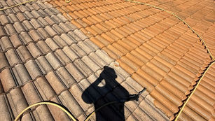 A side-by-side comparison of a tile roof before and after soft wash cleaning. On the left side, the roof appears weathered with dark streaks and organic growth, including algae and moss, dulling the terracotta tiles. On the right side, after professional soft washing, the tiles are bright, clean, and restored to their original vibrant color.