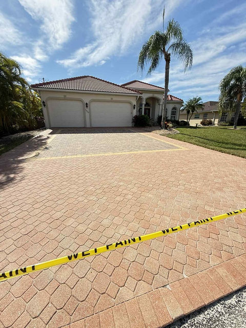 Driveway pavers curing after sealing in Cape Coral, showing restored color and even surface protection during the final stage of the paver sealing process.