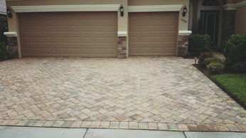 Paver driveway in Cape Coral after a pressure washing service, restored to a clean state.
