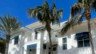 House washing Cape Coral home showing algae buildup on shaded exterior walls before routine soft wash cleaning