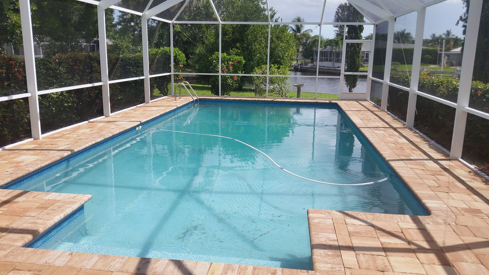 Pool patio pavers and pool cage in Cape Coral, before cleaning.