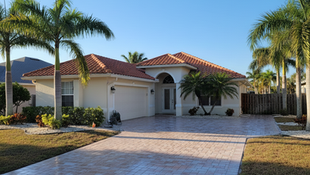 Comparison of paver cleaning and paver sealing on a Cape Coral driveway, showing cleaned pavers versus sealed pavers with enhanced protection.