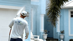 Professional house washing Cape Coral home using soft wash cleaning to remove algae and mildew from stucco exterior