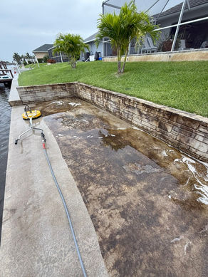Concrete boat dock cleaning Cape Coral in progress with surface cleaner removing dirt and algae buildup