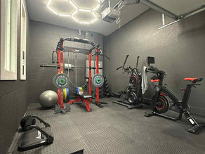 After photo showing epoxy garage flooring and dark gray painted walls during a home gym transformation in Dade City.