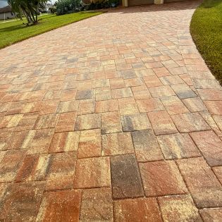 Restored paver driveway after professional pressure washing and sealing, showing rich color and a clean, protected surface.