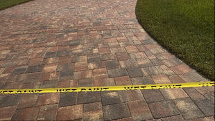 Professional paver sealing service in Cape Coral showing careful preparation and even sealer application on a residential driveway.