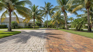 Sun-faded and rain-stained unsealed pavers on a Cape Coral driveway showing moisture damage and color loss before professional paver sealing.