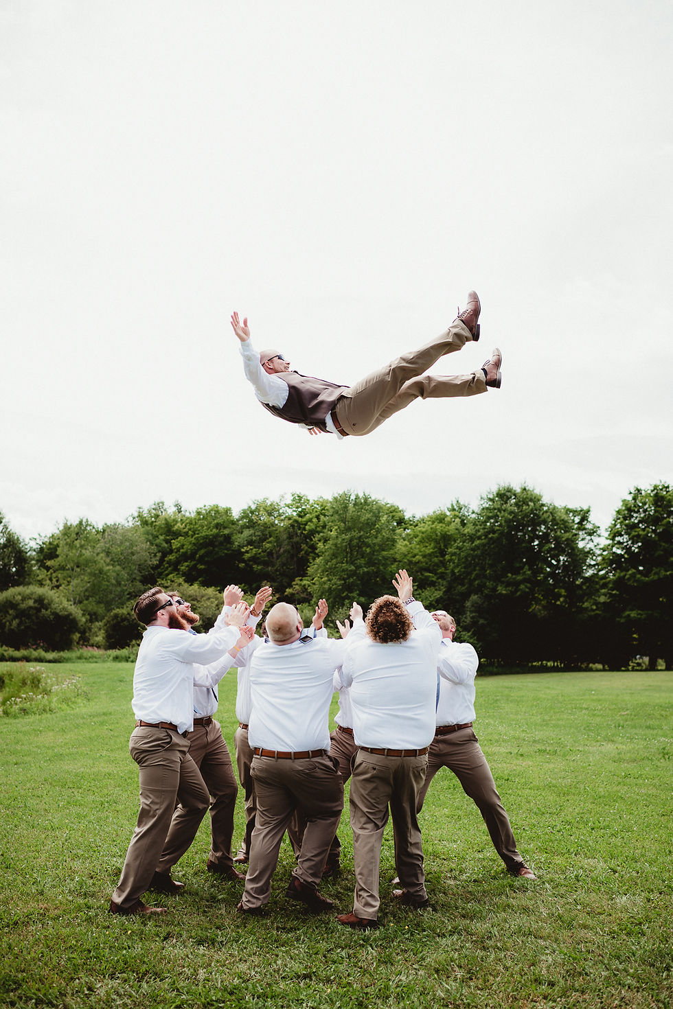 Groom being tossed in the air by groomsmen before his wedding. Rochester, NY photography.
