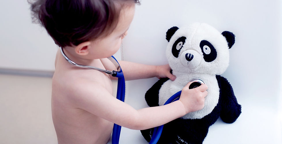 baby with stethoscope playing doctor with teddy bear