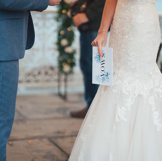 Vow card in brides hand, blue rose detail