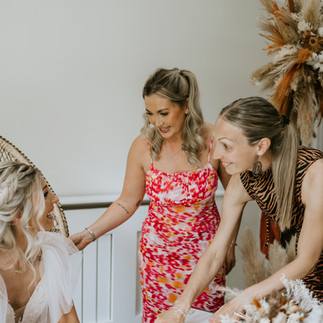 Bride sat down during signing with two guests smiling
