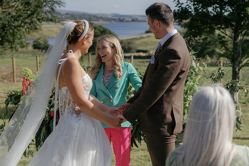 Celebrant with couple during an outdoor ceremony