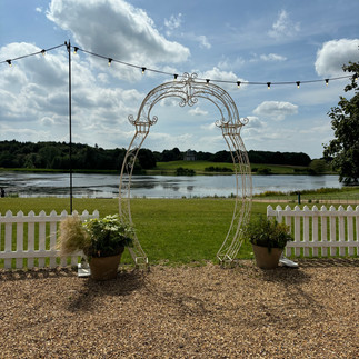 Archway framing the grass, lake and sky
