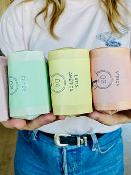 A person holding bags of cofee