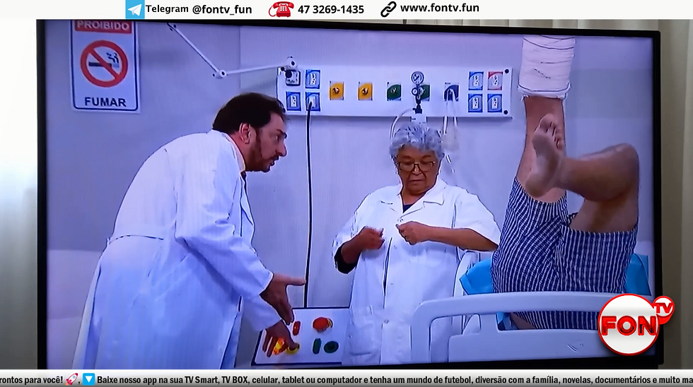 Dois profissionais médicos num quarto de hospital com um paciente levantando um pé enfaixado.