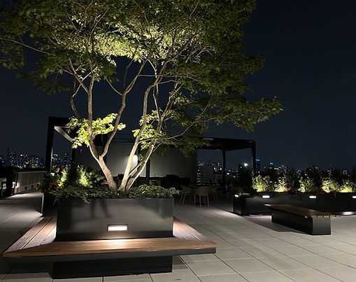 Architectural aluminum planters and Ipe wood benches on the rooftop of the Amara building overlooking NYC.