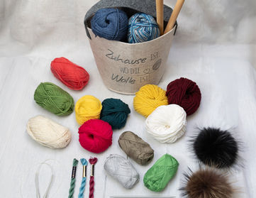 Strickzubehör: Garn, Nadeln, Häkelhaken und Pompons
