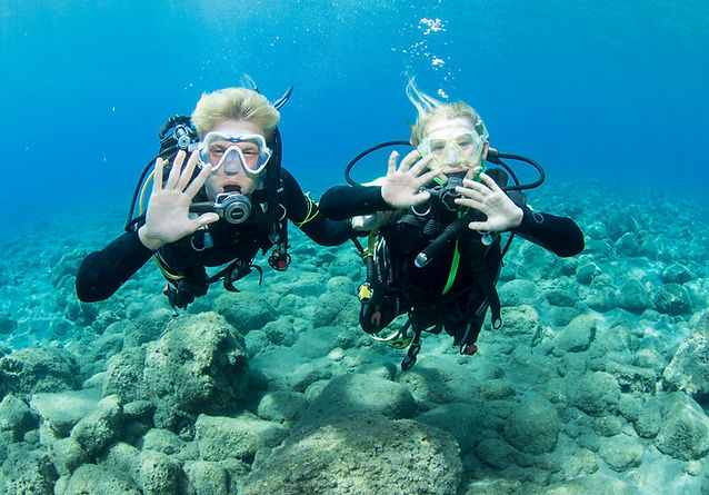 A PADI scuba instructor holding a young girl diving as part of a bubblemaker course in Crete.