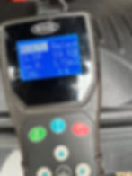 Professional battery health tester showing a "Replace" result with 9% life remaining, part of a mobile car battery diagnostic and replacement service.