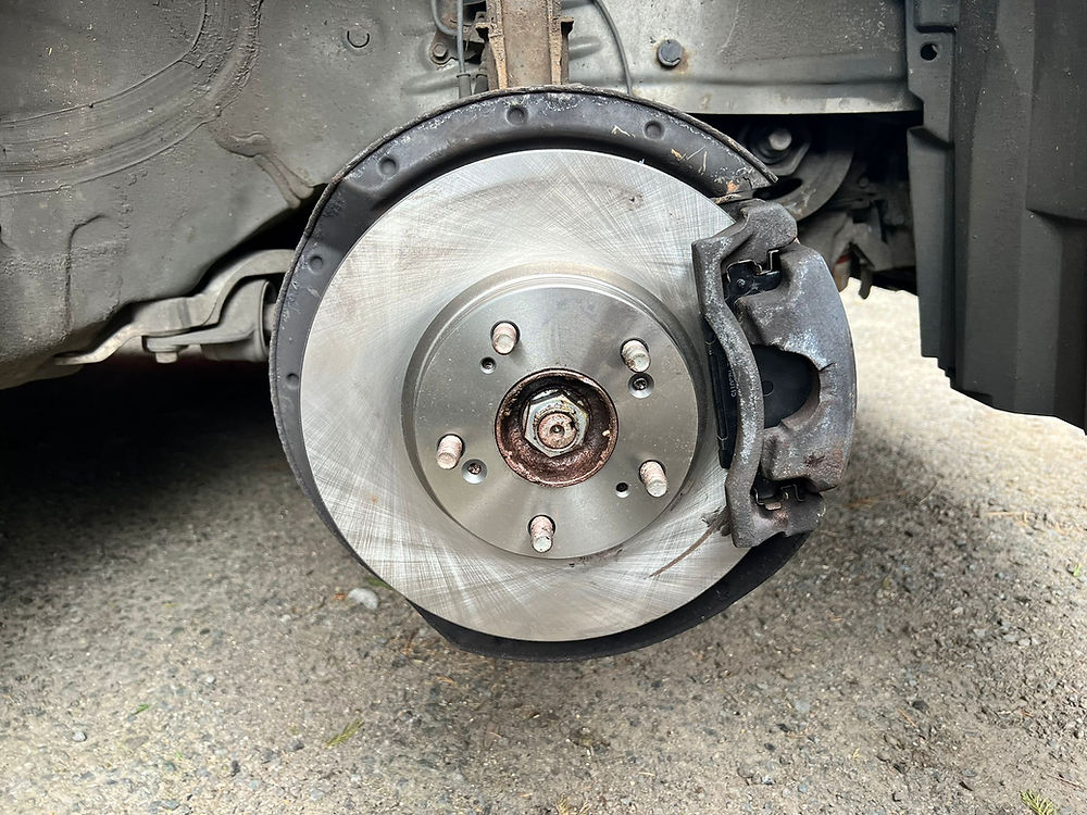 Close-up of a newly installed, high-quality brake disc and caliper assembly, professionally fitted during a mobile brake repair service.