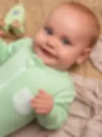 Baby wearing BambooBaby GreenLeaf bamboo sleepsuit, showing comfortable fit and soft fabric feel