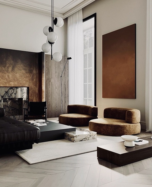 A high-ceilinged living room with velvet armchairs and a globe pendant