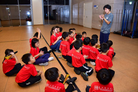 Coach giving words of encouragement to students after the practice of kungfu fan.