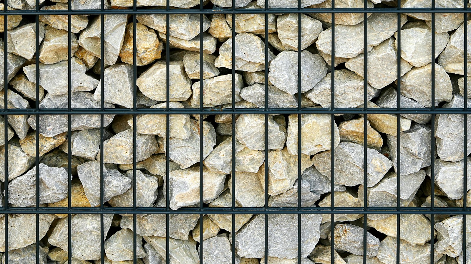 Gabion wall filled with light-colored rocks