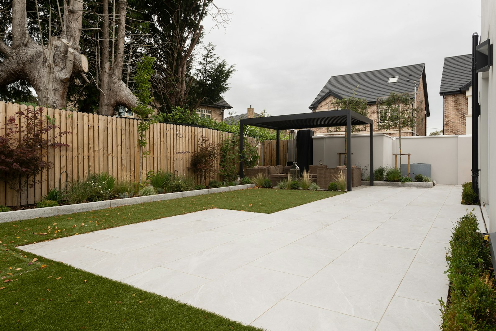 Backyard with a fence, lawn and trees