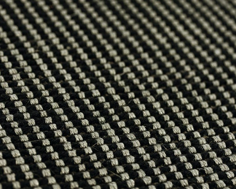 Thumbnail: Close up of dark grey wool rug with camel and black border pattern.