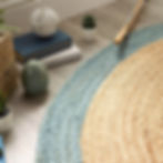 Thumbnail: Round jute rug with blue and natural sections, decorative border.