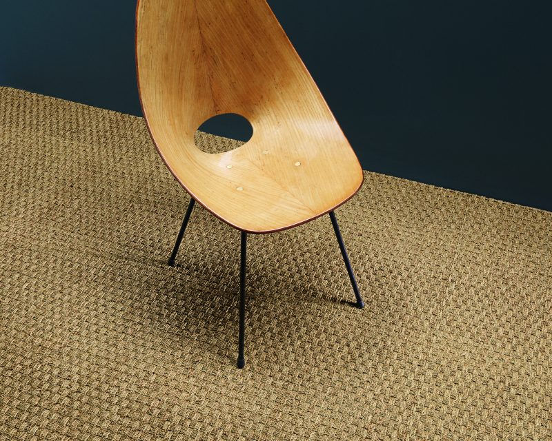 Thumbnail: Basketweave seagrass rug with a linen damson border and a wooden chair.
