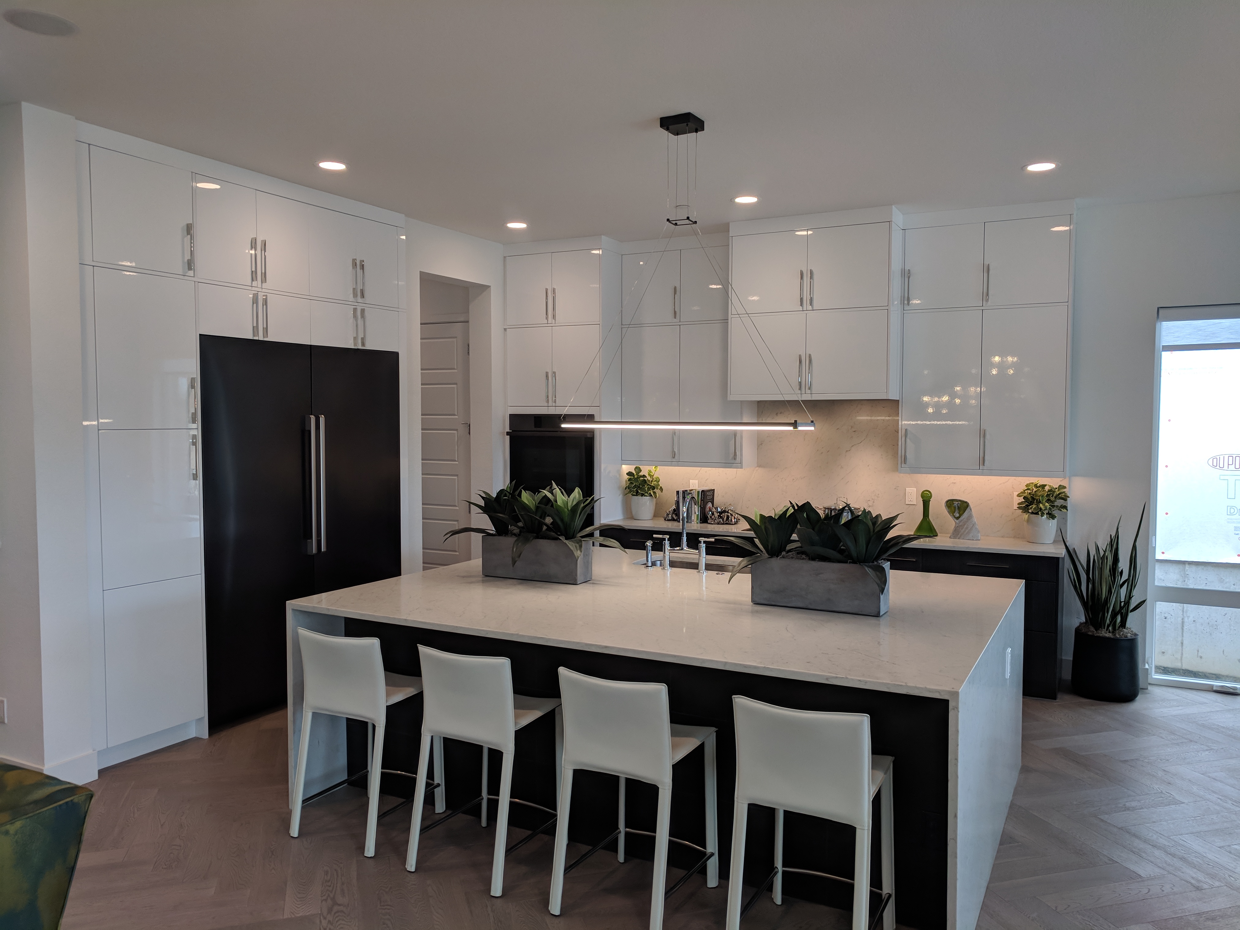 Modern white kitchen with a dark finished island and bar seating