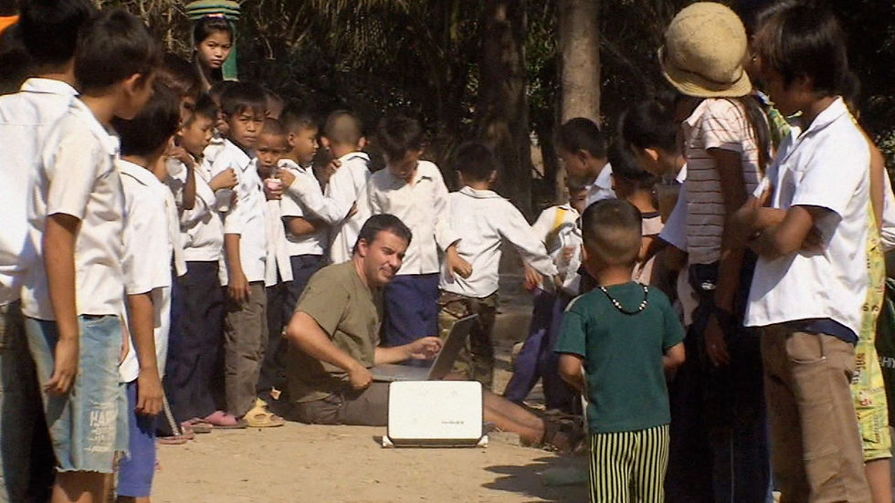 Zsolt w sat modem and kids in Cambodia fr footage.jpg