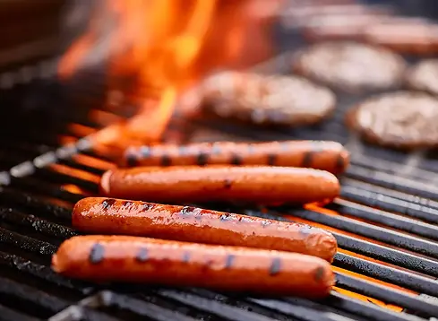 hot-dogs-burgers-on-grill-flames.webp