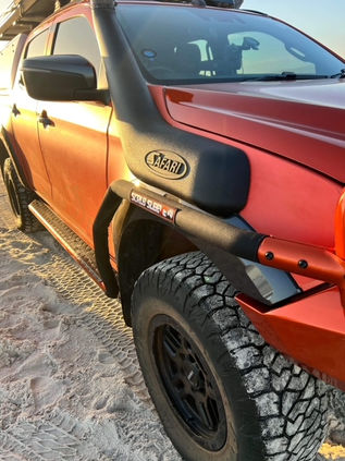 4WD vehicle with Scrub Sleeve installed, navigating through overgrown shrubs and rugged terrain without visible scratches or damage.