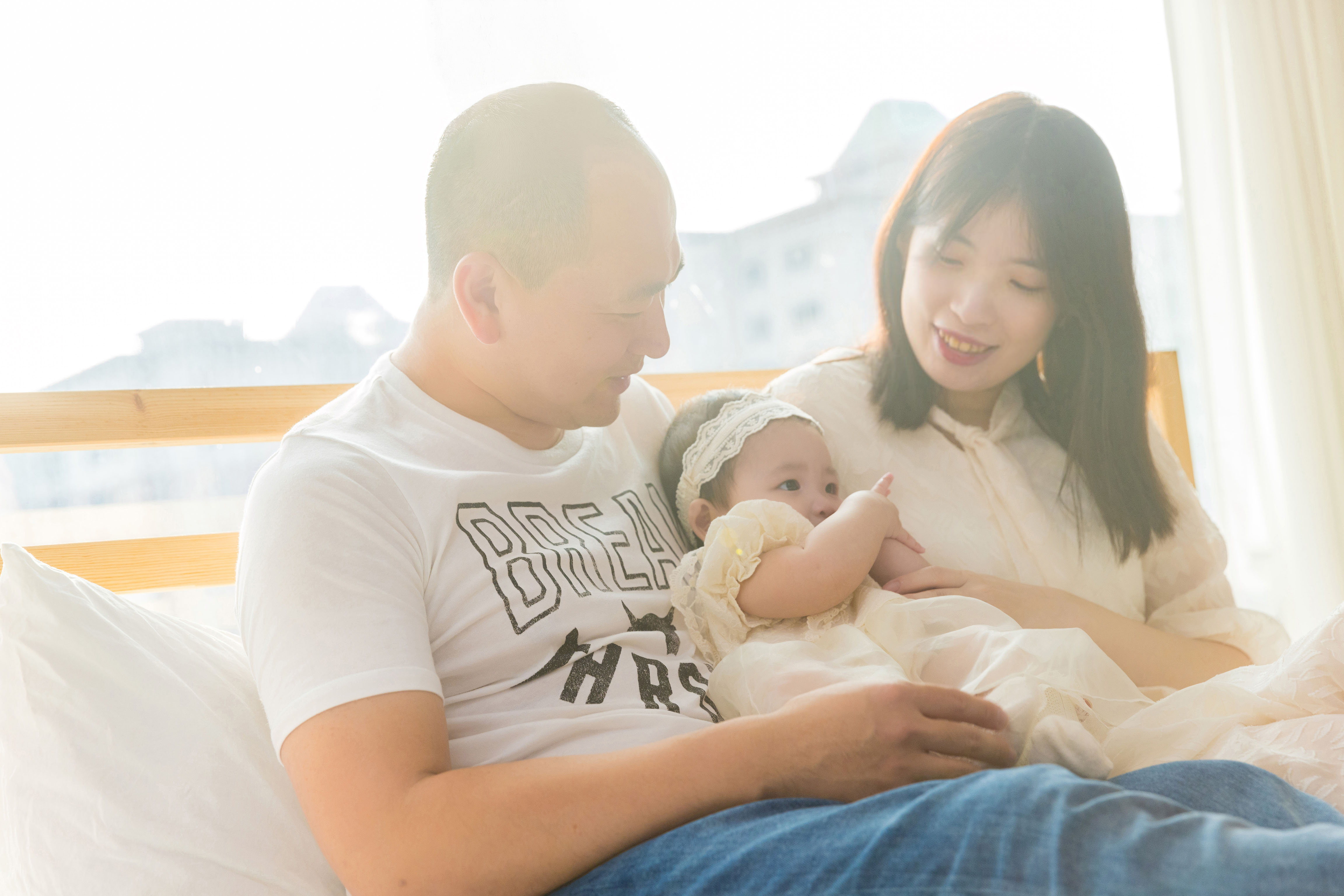 爸爸媽媽與嬰兒在自然光下溫馨互動,親子紀念寫真