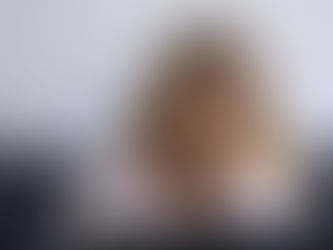 Bewältigung von Krisen: Erschöpfte Frau sitzt vor einem Laptop auf einem Sofa und hält sich angespannt die Augenpartie – ein Bild für Überforderung, berufliche Belastung und emotionale Erschöpfung in Krisenzeiten.