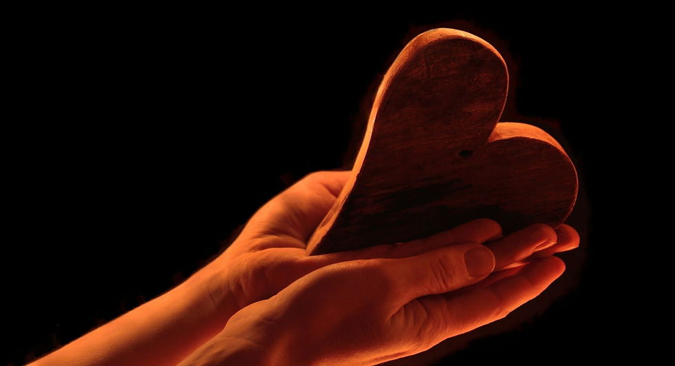 Selbstliebe lernen: Zwei Hände halten ein dunkles Herz im warmen Licht als Symbol für Selbstfürsorge, Selbstmitgefühl und einen liebevollen Umgang mit sich selbst.