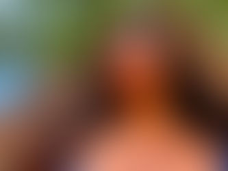 femme à la chevelure curly épaisse et bouclée lunettes de soleil arbres ciel bleu