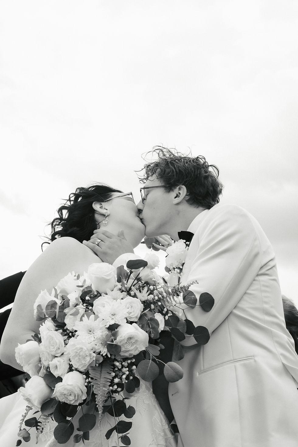 Evelyn and Charles sharing their first kiss during their outdoor wedding ceremony at The Oaks at Plum Creek in Colorado.