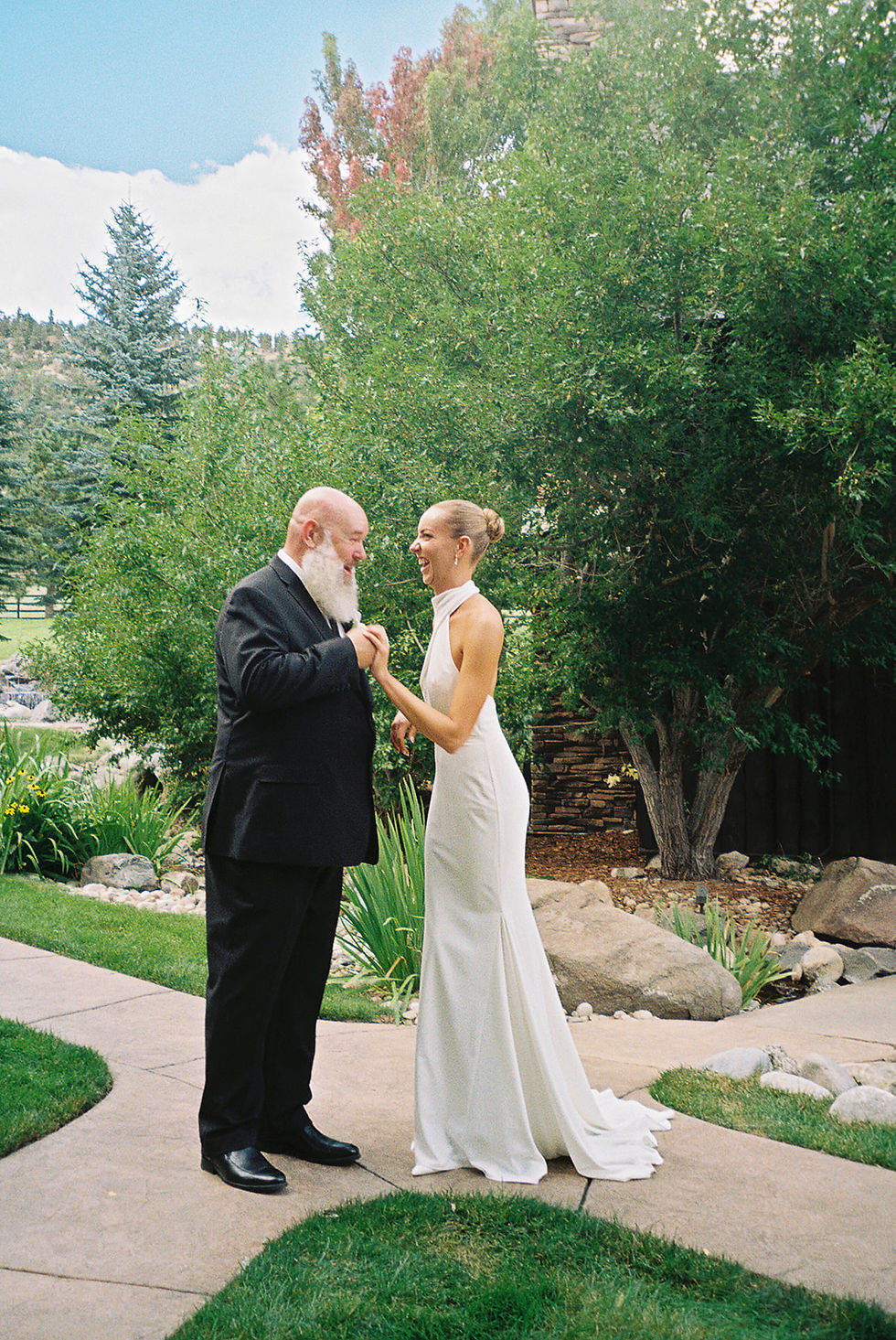 Bride Kennedy sharing a special moment with her father outdoors at Spruce Mountain Ranch in Colorado.