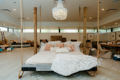 Spacious bridal suite with a hanging swing bed and elegant décor at The Oaks at Plum Creek wedding venue in Castle Rock, Colorado.