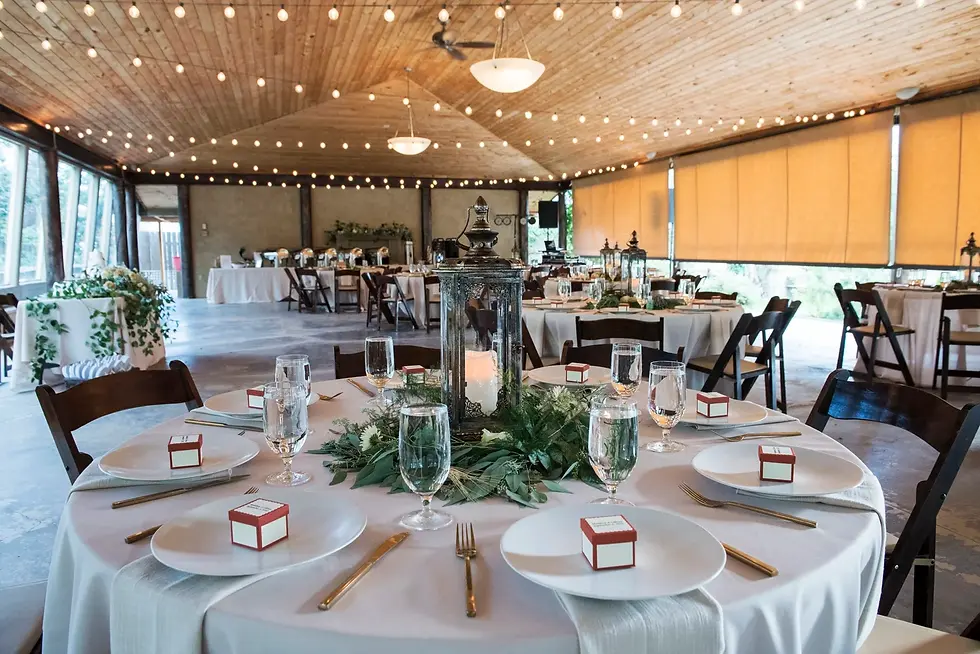 Wedding reception setup inside the pavilion at Hillside Gardens wedding venue in Colorado Springs with string lights and round tables.