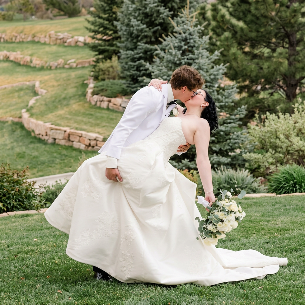 Bride and groom sharing a dip kiss at The Oaks at Plum Creek during their Colorado wedding.