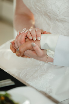 Bride and groom holding hands during their wedding ceremony.