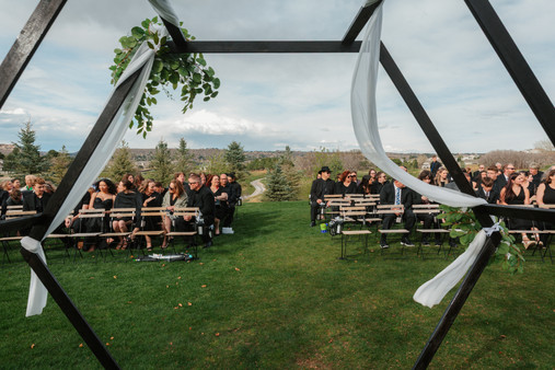 Outdoor wedding ceremony setup with geometric arch, white draping, and guest seating overlooking the golf course at The Oaks at Plum Creek in Castle Rock, Colorado.